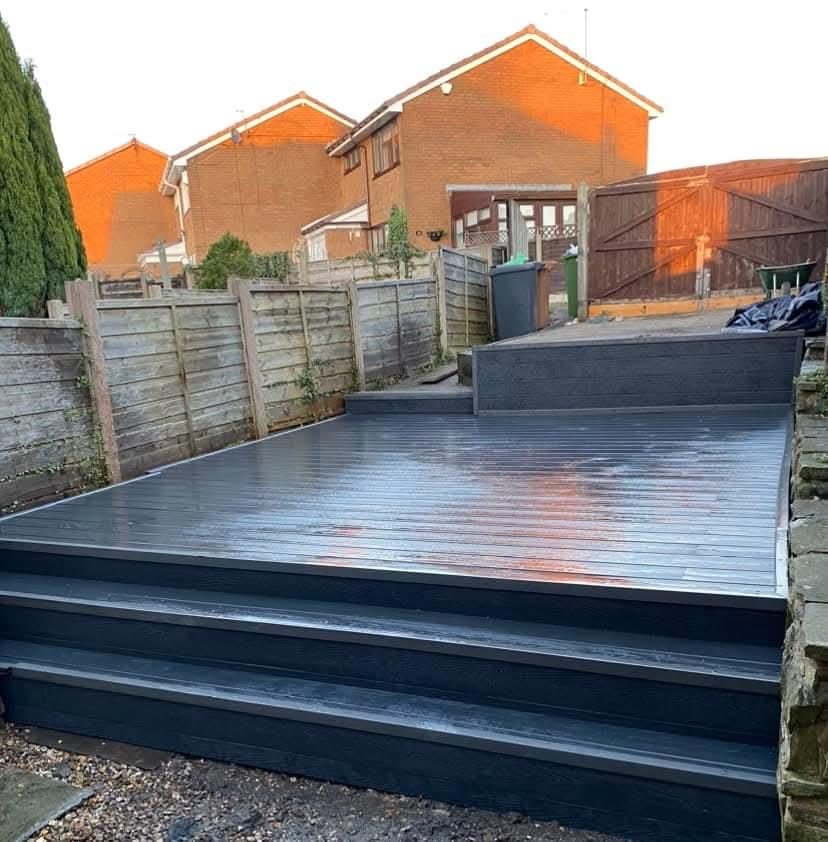 Dark composite deck with wide steps in the same garden