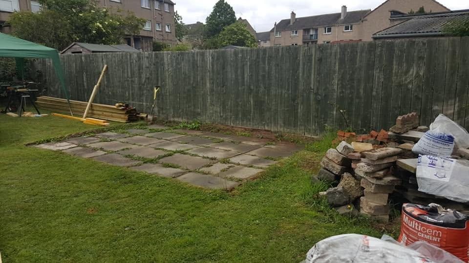 Lawn with old slabs, bricks and materials before a deck was built