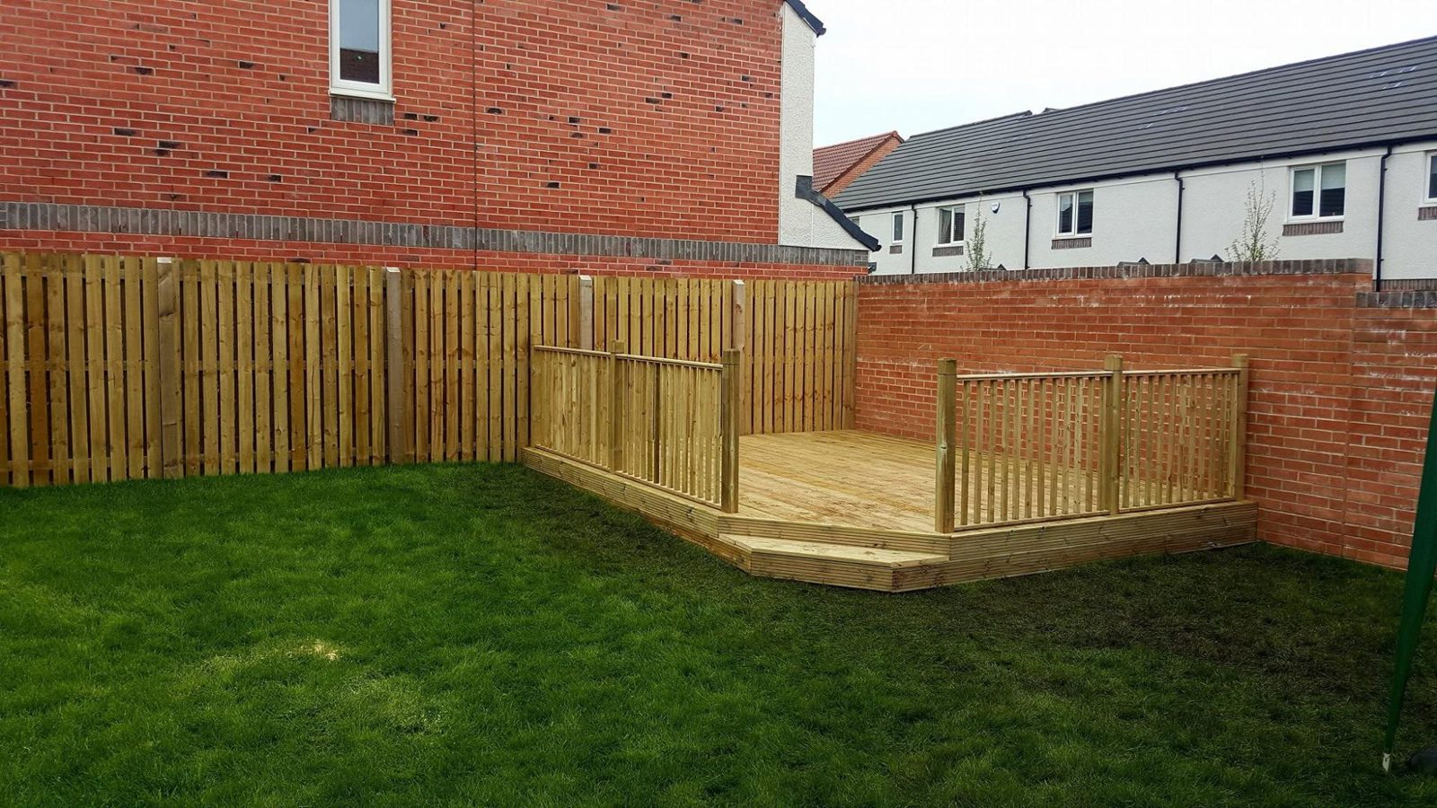 Raised timber deck with a balustrade on a lawn