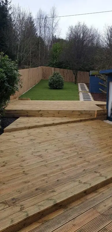 Two-level timber deck with steps, a lawn and a close-board fence