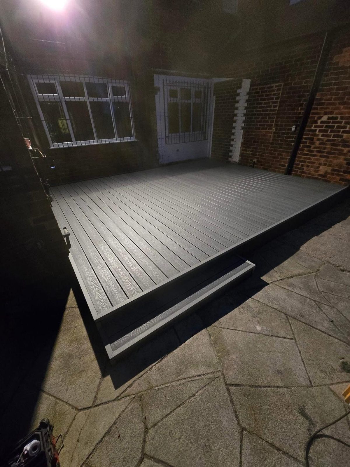 Grey composite deck built over the same side yard