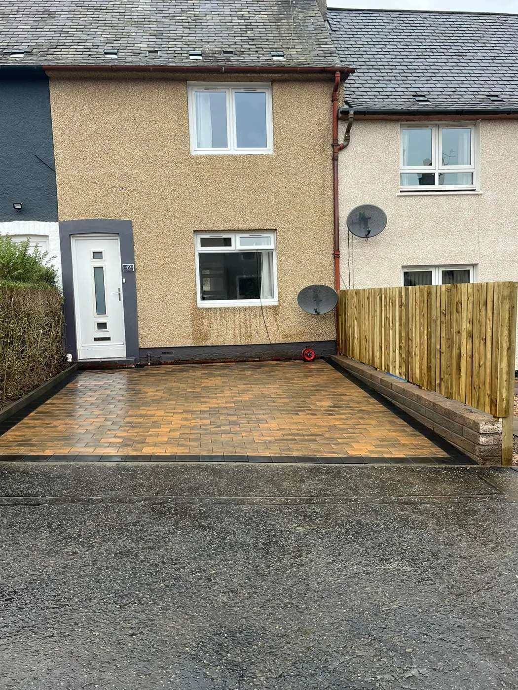 New tan block paving and a timber fence at the same house