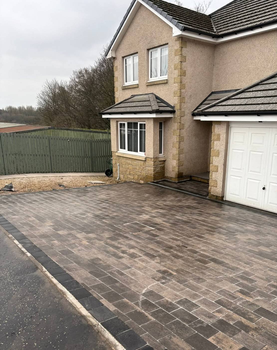 New grey block-paved driveway at the same house and garage