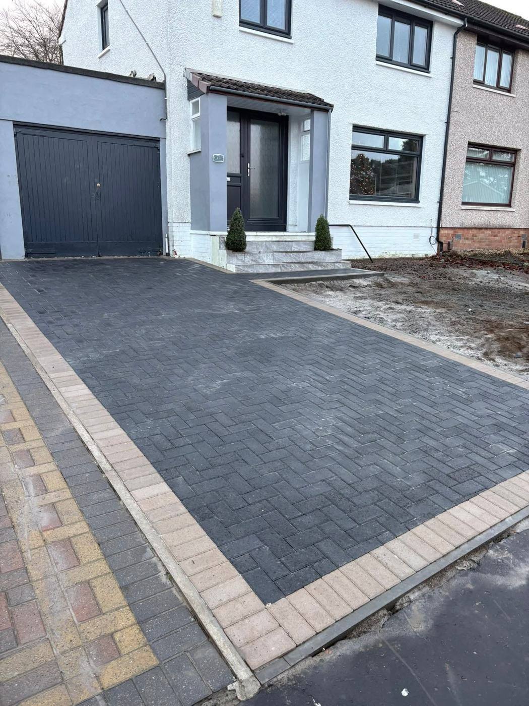 New charcoal block driveway with a light border at the same house