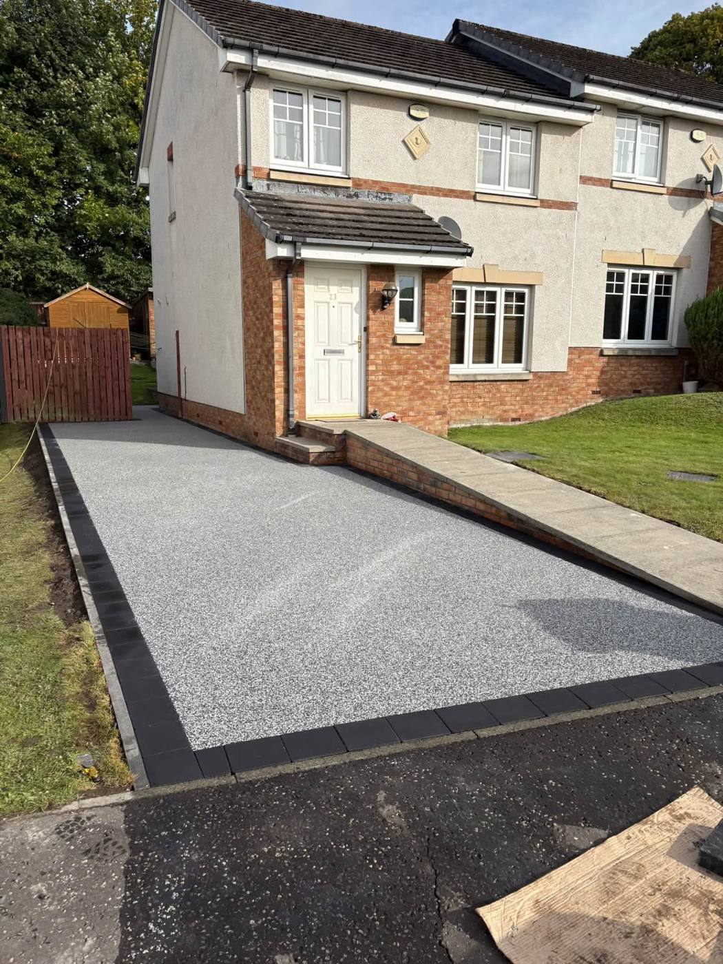 New silver resin driveway with a black block border at the same house