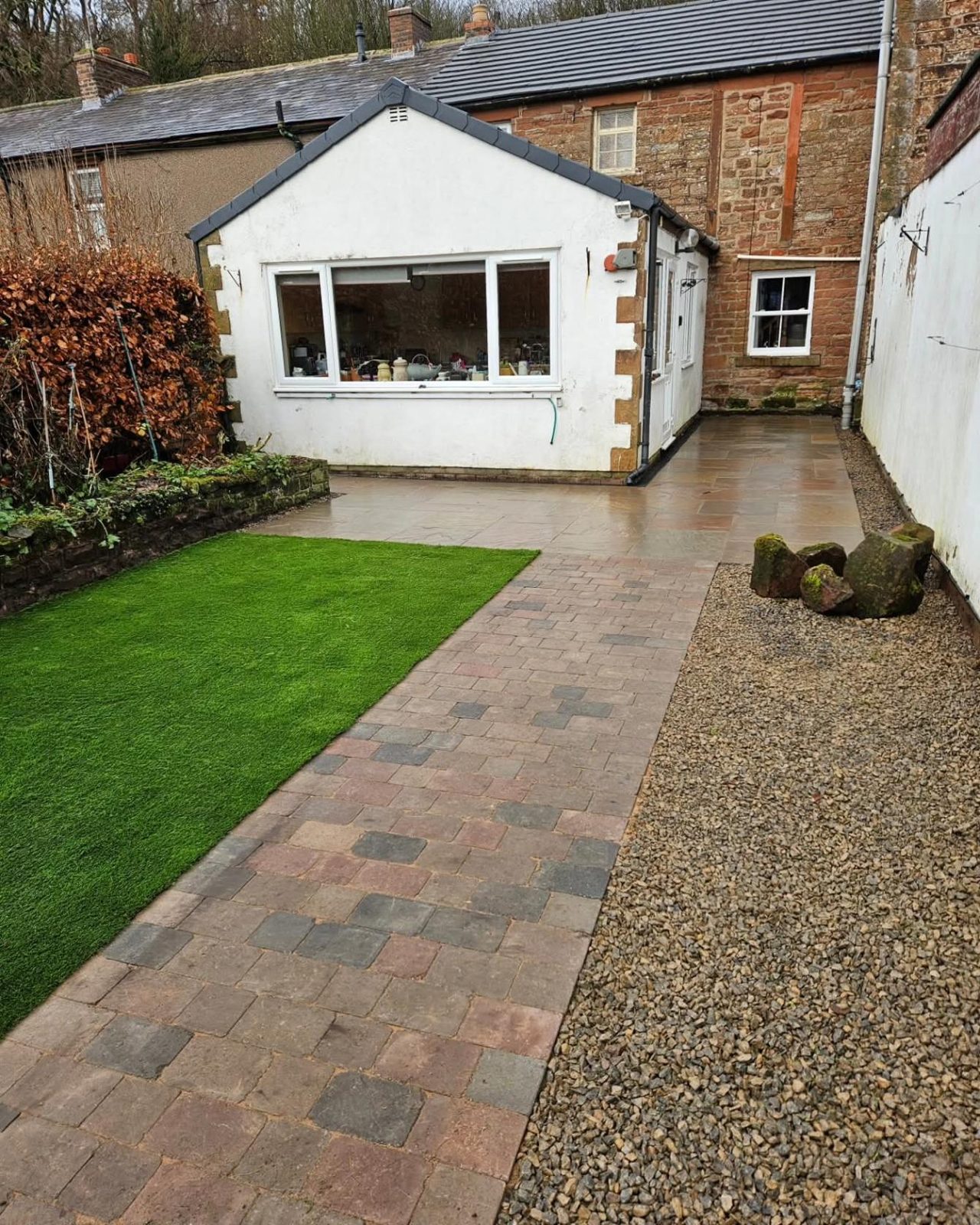 Block paving, artificial grass and gravel outside the same extension