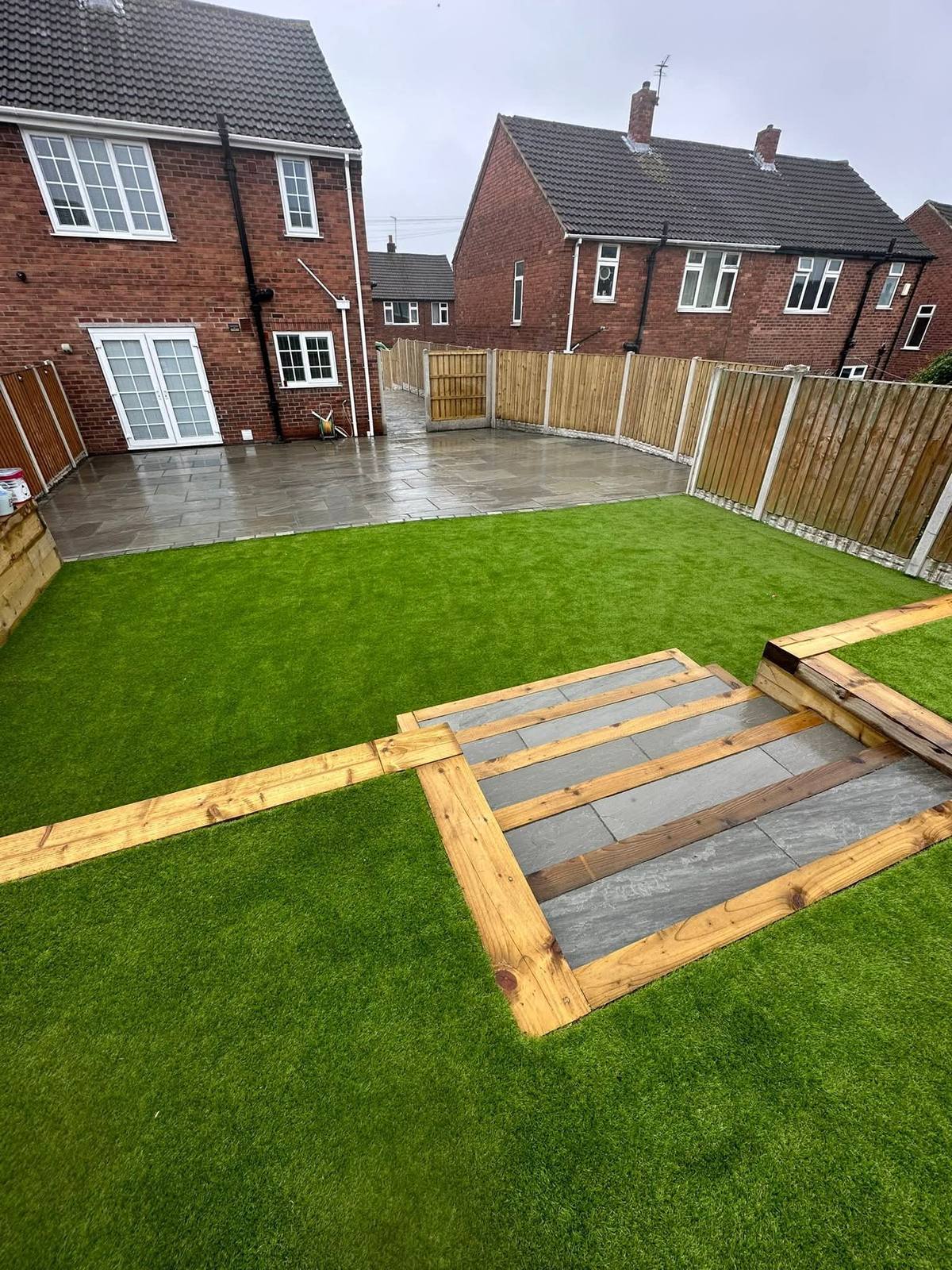 Artificial grass, a timber-edged path and new paving in the same garden
