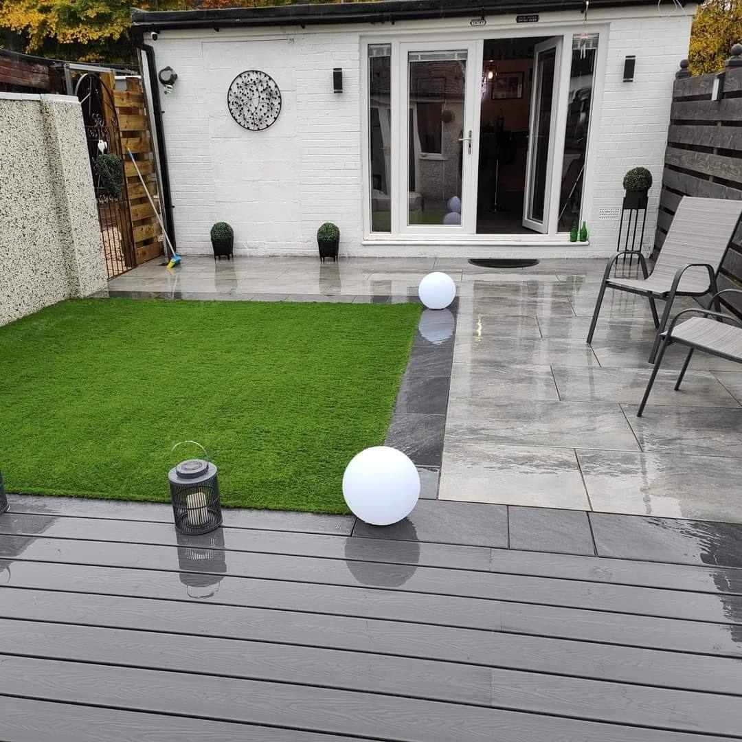 Finished patio, artificial lawn and grey composite deck outside the garden room