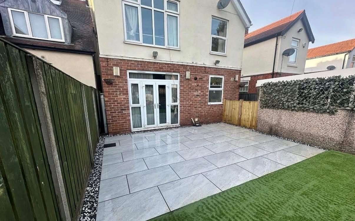 Light porcelain patio beside artificial grass at the same house