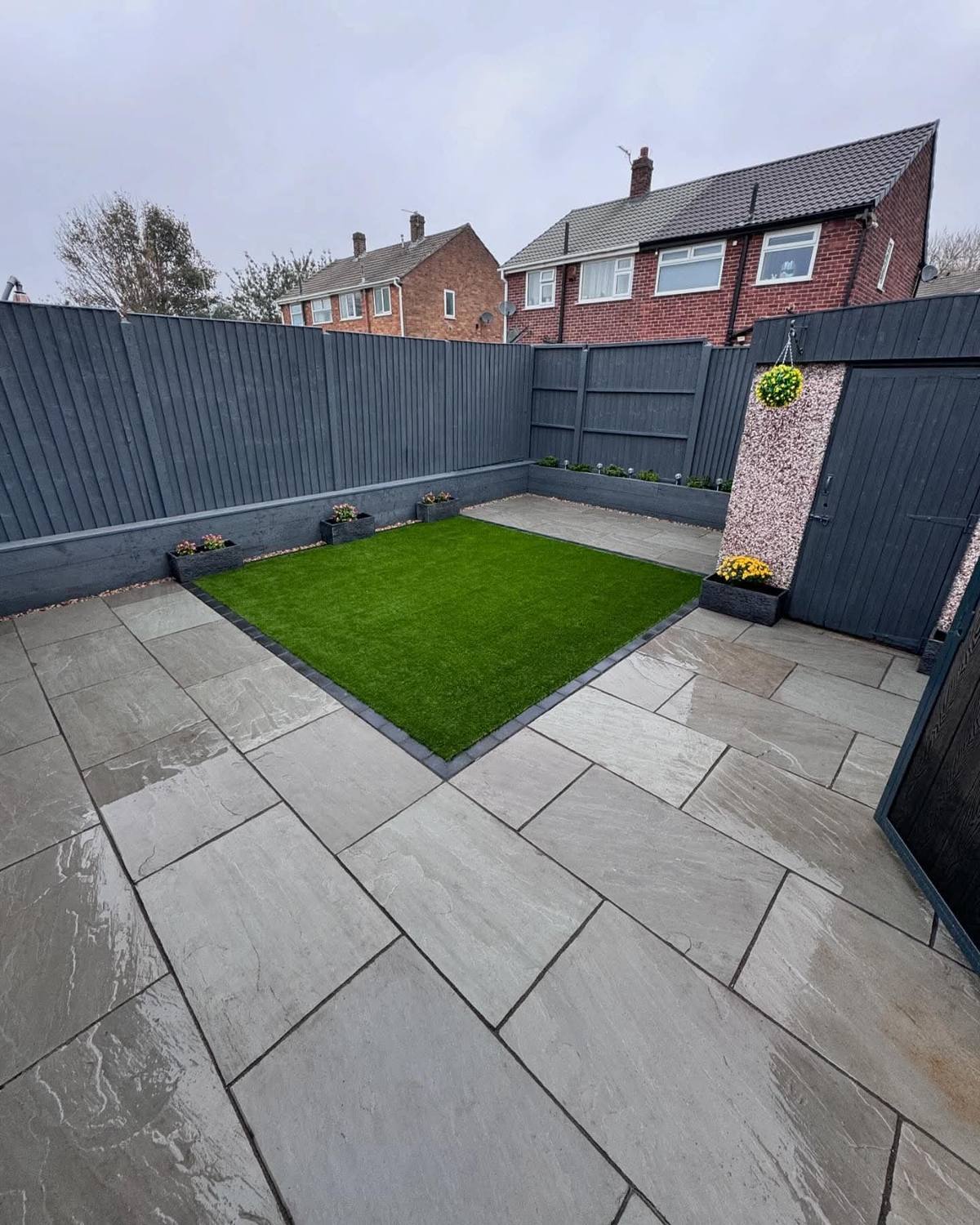 New porcelain patio and artificial grass inside the same grey fence
