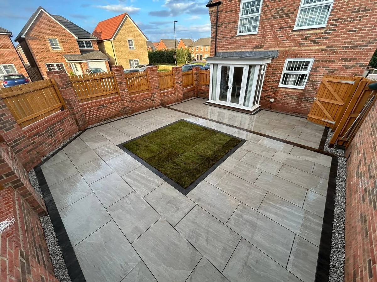 Finished porcelain patio with an artificial grass inset in the same garden