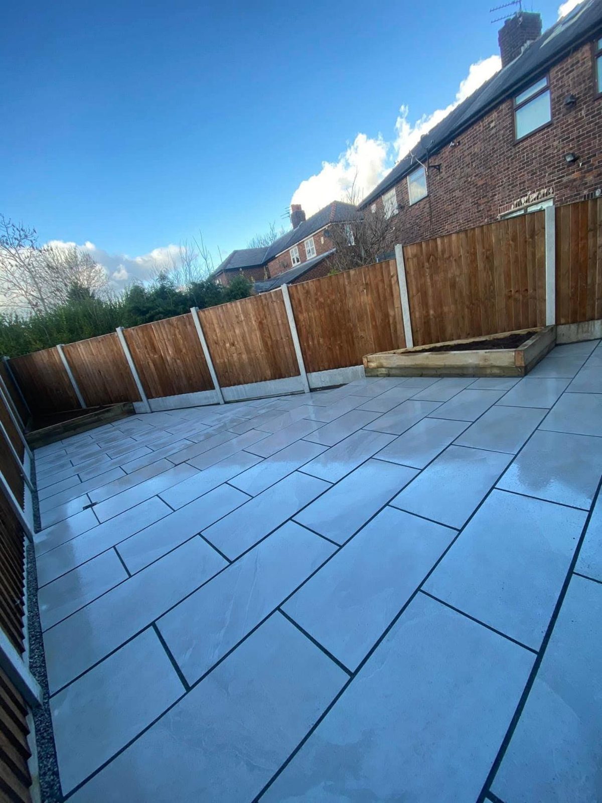 Light porcelain patio with a raised timber planter