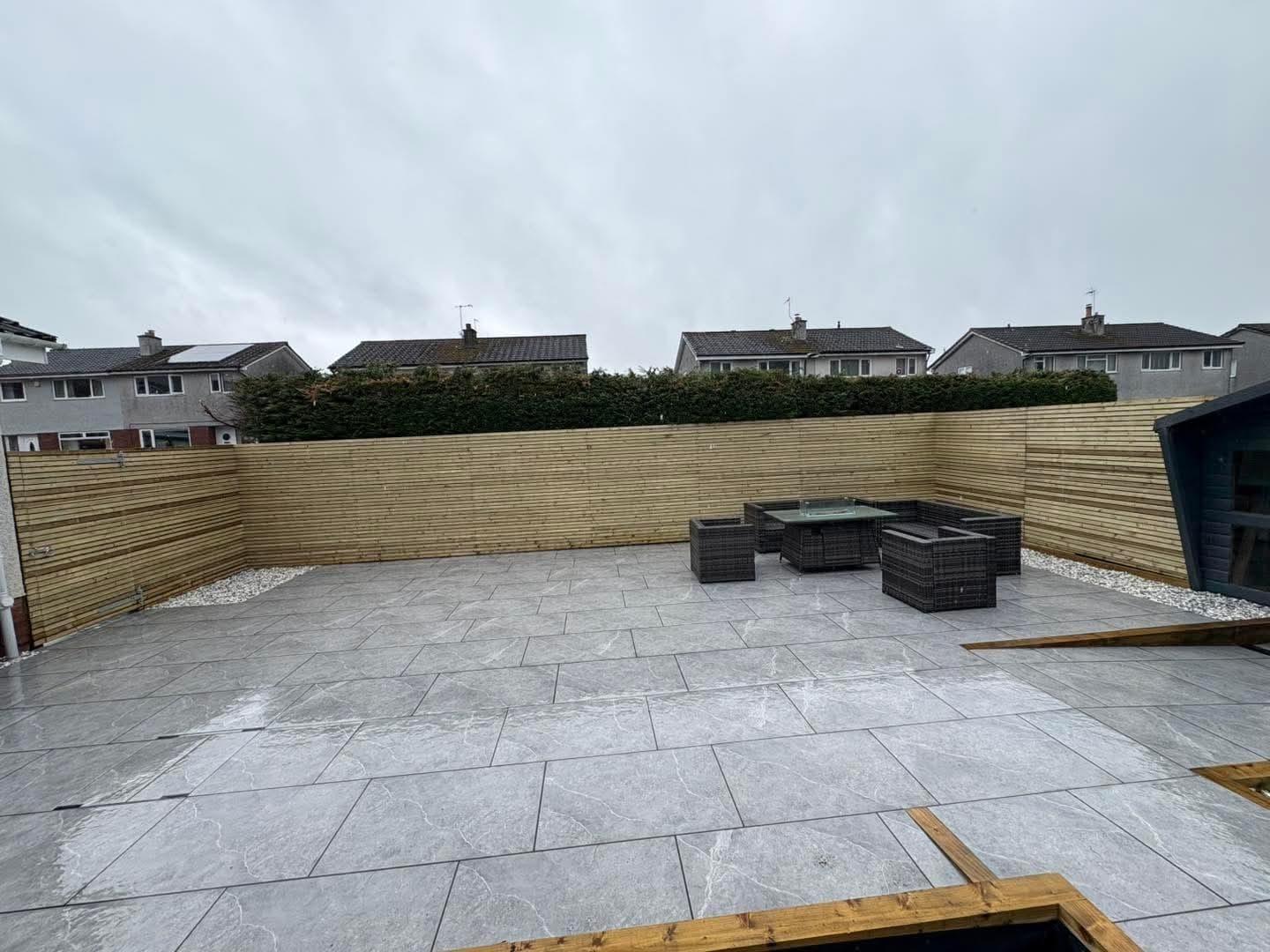 Grey porcelain patio inside a new horizontal-slat fence