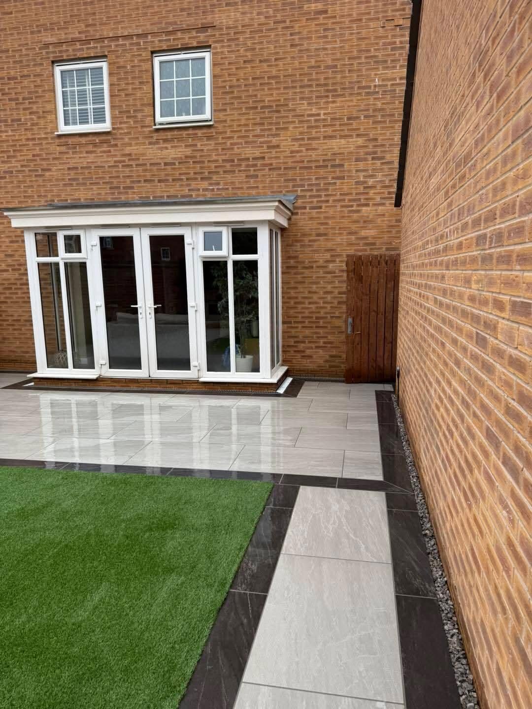 Porcelain patio and artificial grass outside the same conservatory