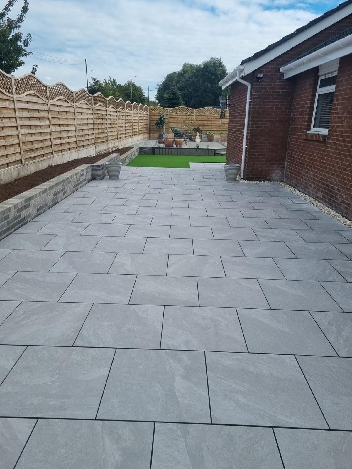 Grey porcelain patio and artificial grass in the same garden