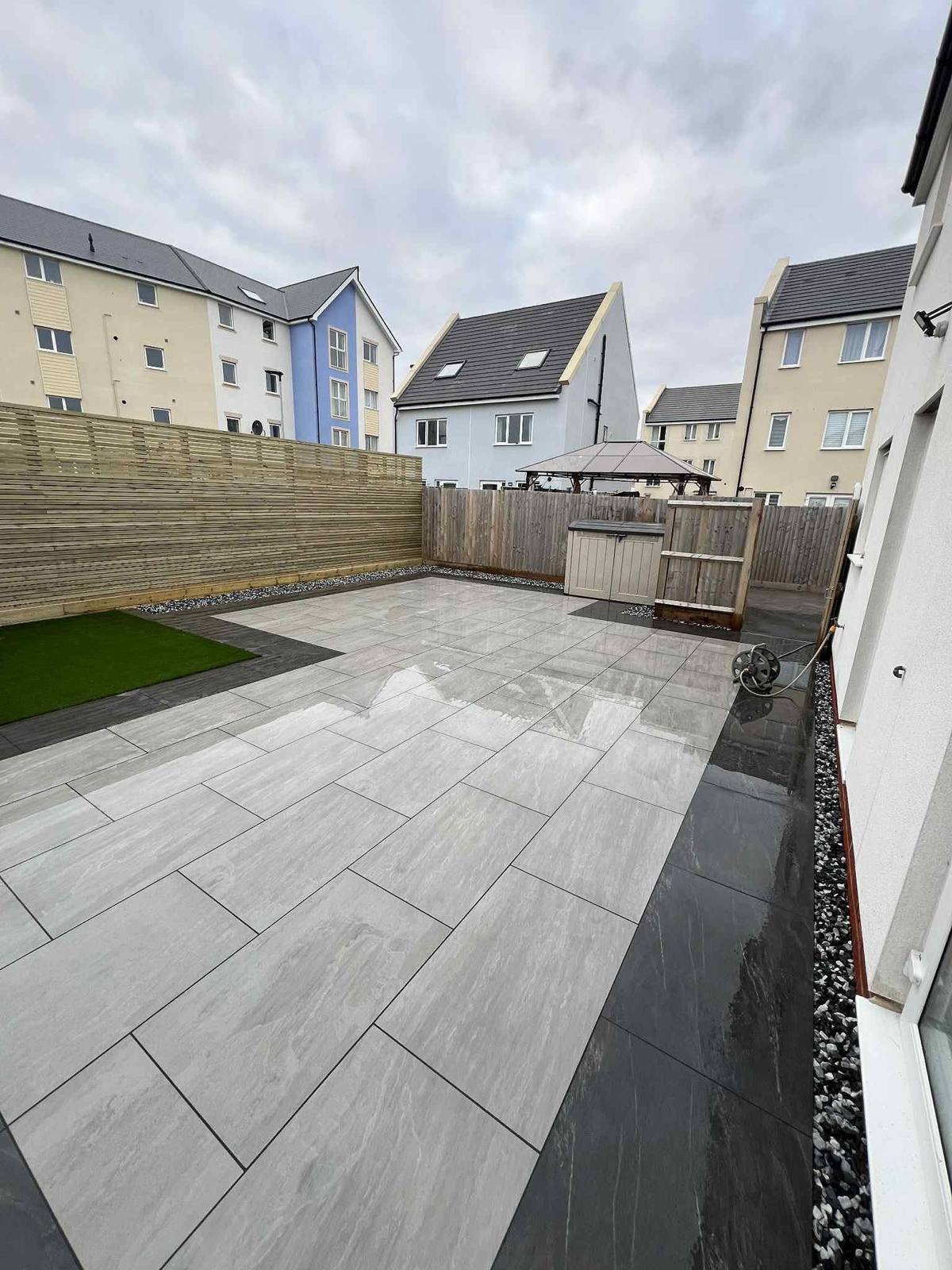 Porcelain patio and a corner of artificial grass where the weeds were