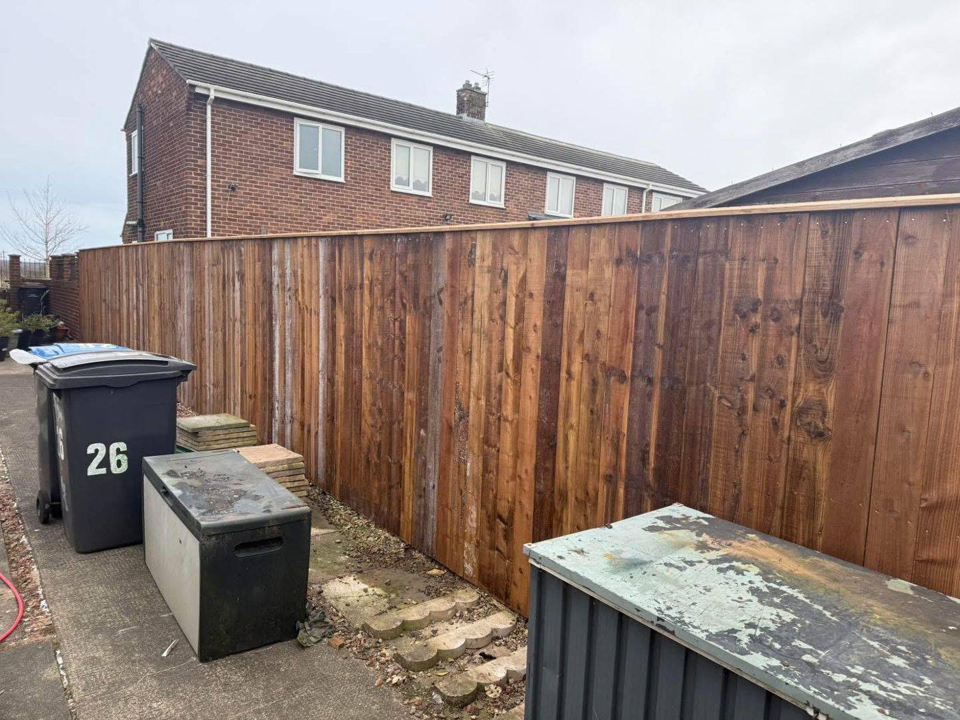 New close-board fence in the same spot, with the bins and freezer still there