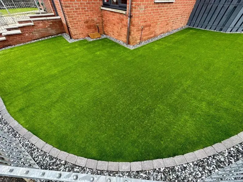 Artificial grass with a block edge inside the same railings
