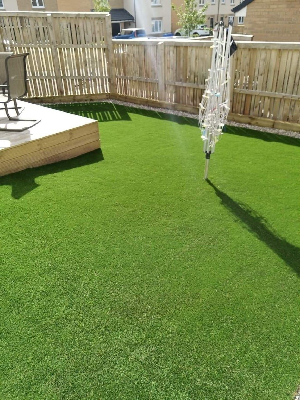 Artificial grass beside the same timber deck and fence