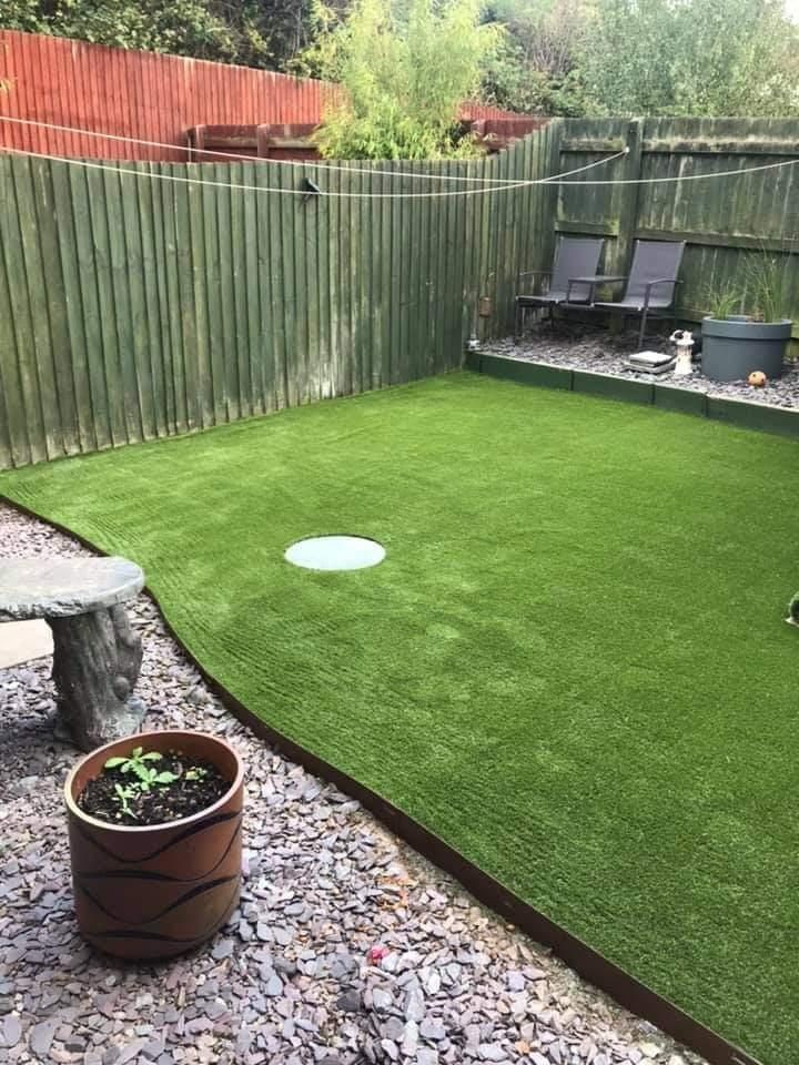 Artificial grass in front of the same green fence