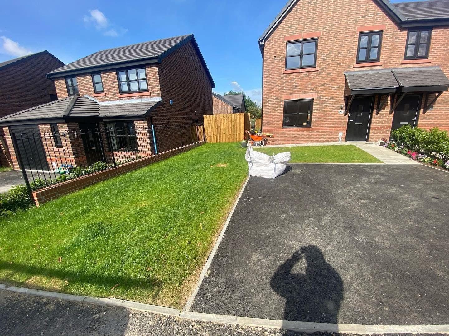 Real grass beside a new tarmac drive before it was replaced